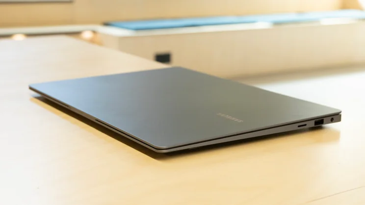 The Samsung Galaxy Book5 Pro pictured closed on a pale wood surface